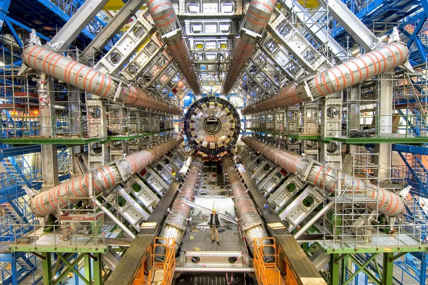 The ATLAS detector under construction in 2005. The eight large magnets (toroids) are used to bend the path of charged particles, which helps identify them. Standing in the middle, for scale: Roger Ruber, who led the commissioning of another magnet from ATLAS, the solenoid (not pictured).